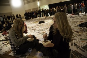 Left to right: Miranda Whittington and Jennifer Bennett eat rice and beans on a tortilla as they take the role of those living in poverty.