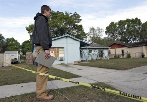 An engineer stands in front of a home where a sinkhole opened up on Friday. (AP Photo)