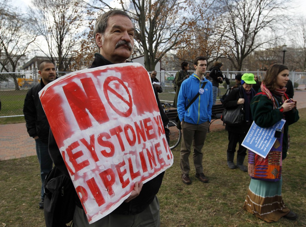 Protestors gather in the White House gate in Washington, Wednesday, before top environmental leaders tied themselves to the gate to protest the Keystone XL oil pipeline. (AP Photo)
