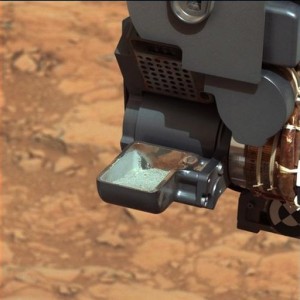 This image released by NASA shows the Curiosity rover holding a scoop of powdered rock on Mars. (AP Photo)