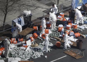 Investigators comb through the post finish line area of the Boston Marathon at Boylston Street, two days after two bombs exploded just before the finish line. (AP Photo)