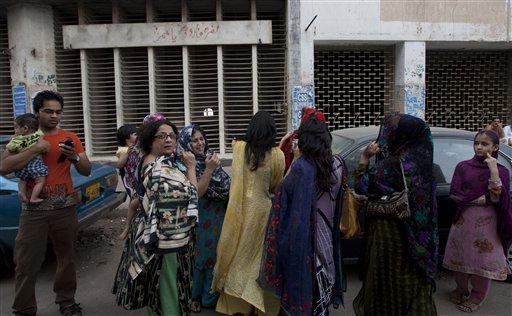 People evacuate buildings and gather on road after a tremor of an earthquake was felt in Karachi, Pakistan. (AP Photo)