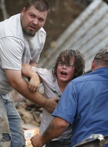 A child calls to his father after being pulled from the rubble of the Tower Plaza Elementary School following a tornado in Moore, Okla., Monday, May 20, 2013. A tornado as much as half a mile (.8 kilometers) wide with winds up to 200 mph (320 kph) roared through the Oklahoma City suburbs Monday, flattening entire neighborhoods, setting buildings on fire and landing a direct blow on an elementary school. (AP Photo by Sue Ogrocki)