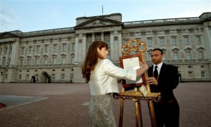 The Queen's Press Secretary Ailsa Anderson with Badar Azim, a footman, places an official document to announce the birth of a baby  boy, at 4.24pm to the William and Kate, the Duke and Duchess of Cambridge at St Mary's Hospital,  in the forecourt of Buckingham Palace in London Monday July 22, 2013. The child is now third in line to the British throne.  (AP Photo/John Stillwell, Pool)