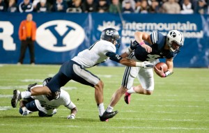 BYU quarterback Taysom Hill is pursued by Utah State defenders Brian Suite (21) and Will Davis (17) on Friday night at LaVell Edwards Stadium.  The Cougars beat the Aggies 6-3. - Luke Hansen