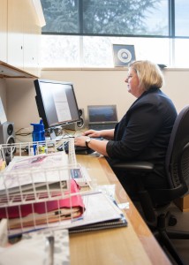 Dean Prater takes a break from moving into her new office to get some work done.