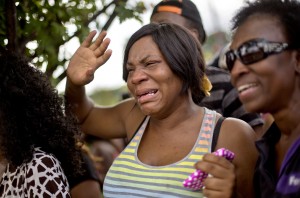 Sparkle Potts, left, cries upon seeing her nephew Cameron Bell pull up in a school bus from Ronald E. McNair Discovery Learning Academy while waiting with his grandmother Arvis Potts, right, in a Wal-Mart Inc., parking lot after students were evacuated when a gunman entered the school, Tuesday, Aug. 20, 2013, in Decatur, Ga. (AP Photo by David Goldman)