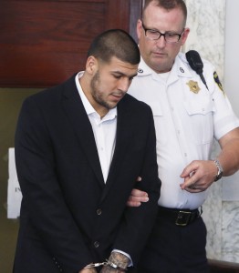 Former New England Patriots NFL football tight end Aaron Hernandez, left, is escorted into Attleboro District Courtroom for his probable cause hearing on Wednesday, July 24, 2013, in Attleboro, Mass. Hernandez has pleaded not guilty to murder in the death of Odin Lloyd, a 27-year-old Boston semi-professional football player whose body was found June 17 in an industrial park in North Attleboro near Hernandez's home. (AP Photo by Bizuayehu Tesfaye)