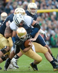 BYU defensive lineman Bronson Kaufusi sacks Notre Dame quarterback Tommy Rees. Photo by Chris Bunker