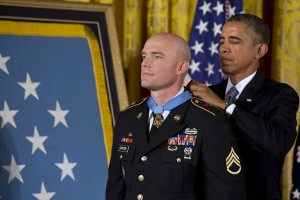 President Barack Obama awards US Army Staff Sgt. Ty M. Carter the Medal of Honor for conspicuous gallantry, Monday, Aug. 26, 2013, during a ceremony in the East Room of the White House in Washington. (AP Photo/Jacquelyn Martin)
