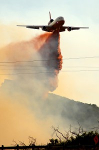 A DC-10 air tanker drops fire retardant near the Rockport fire in Rockport, Summit County, Wednesday, Aug. 14, 2013.  Fire officials say a wildfire that's already burned at least 14 homes near Park City has been spreading in gusty winds.  (AP PHOTO by Scott Jones)