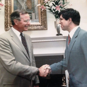 Lew Cramer, right, shakes hands with former President George H.W. Bush.