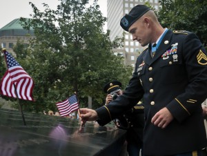 Medal of Honor recipient Staff Sgt. Ty Carter places a flag on a section of the 9/11 Memorial on Thursday, Aug. 29, 2013, in New York. (Photo courtesy AP Photo/Bebeto Matthews)