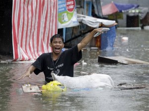 A resident gestures as he wades through a flooded street at suburban Quezon city, northeast of Manila Monday, Sept. 23, 2013 following heavy rains brought about by Typhoon Usagi.  (AP Photo/Bullit Marquez)
