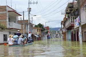 Villagers are evacuated from flooded areas in the town of Tixtla de Guerrero, Mexico, Sunday, Sept. 22, 2013.  Tropical Storm Manuel and Ingrid affected 24 of Mexico's 31 states and 371 municipalities, which are the equivalent of counties. More than 58,000 people were evacuated, with 43,000 taken to shelters. Nearly 1,000 donation centers have been set up around the country, with nearly 700 tons of aid delivered so far.  (AP Photo/Alejandrino Gonzalez)