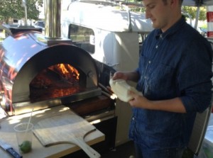  Matt Reschke, an advertising major at BYU, molds Italian-style dough into a pizza before placing it into the oven at the Provo Farmer's Market. Photo by Lucy Schouten.