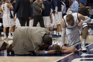 Erik Mika is attended to by teammate Nate Austin and the team trainer after Mika took a hard blow from DeAndre Kane. Kane was ejected from the game. Photo by Natalie Stoker.
