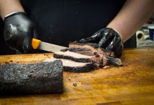 Cameron Treu is carefully slicing briskets made from the highest quality of beef at Bam Bams BBQ off of State Street in Orem. (Photo by Samantha Williams.)