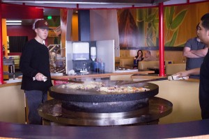 Customers at Mongos' Stirfry fill their own bowls with many choices of ingredients and then watch as each dish is grilled on the round hot rock table grill in front of them. (Photo by Samantha Williams.)