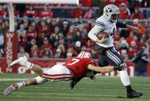 Taysom Hill tries to break away from Wisconsin's Michael Caputo during the first half of Saturday's game against Wisconsin. Photo courtesy AP Photo/Morry Gash)
