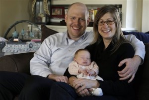 Ken Ernst, left, and his wife Abigail Ernst, right, pose with their 2-month-old daughter, Lucy, in their Oldwick, N.J. home. The couple conceived Lucy by using only one embryo through in vitro fertilization. AP Photo.