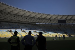Workers paint white lines on the grass during an inspection tour of Maracana stadium in Rio de Janeiro, Brazil. AP Photo.