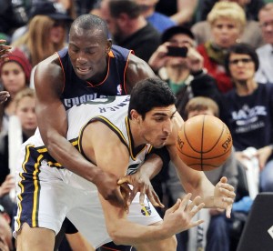 Charlotte Bobcats' Bismack Biyombo, left, goes over the back of Utah Jazz's Enes Kanter as they try for the loose ball. AP photo