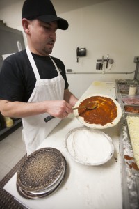 Manny Chacon, the owner of Two Jack's Pizza, prepares pizza pies for customers. Pizzas at Two Jack's are made with fresh ingredients. Customers can walk up by the kitchen and have a quick chat with whoever happens to be making their food. Oftentimes restaurant owner Chacon is the one making the pizza. (Photo by Elliott Miller.)