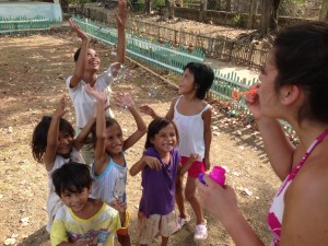 Lydia Nielsen (far right) blows bubbles with children in a remote village in the Philippines. Revive brought the inhabitants living supplies and toys for the kids. Photo courtesy of Lydia Nielsen.
