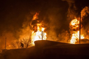 In this photo provided by the Ministry of Emergency Situations Kirov Branch press service, men are silhouetted against burning tankers. 