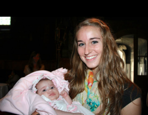 Ashleigh Cox holds a Romanian baby at an Orthodox baptism. Cox died Sunday, Feb. 9, after sustaining injuries from an avalanche Saturday, Feb. 8.