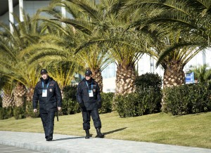 Russian police officers walk past a row of palm trees while taking in the sunny mild temperatures before the 2014 Sochi Winter Olympics in Sochi, Russia on Tuesday, Feb. 4, 2014.  (AP Photo/The Canadian Press, Nathan Denette)