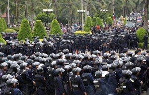 Thai policemen with full riot gears form up lines after anti-government protesters enter in to the Command Management for Peace and Order (CMPO) office during a rally Friday, Feb. 21, 2014 in Bangkok, Thailand (Photo courtesy Associated Press)