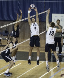 Tyler Heap (9) sets a ball during a men's volleyball game.