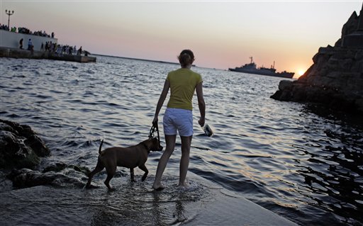 A girl plays with her dog in Sevastopol, Ukraine. AP photo.