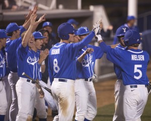 Players celebrate after Hayden Nielsen scores a run for BYU.