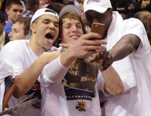 Wichita State's Ron Baker, center, takes a photo with Fred VanVleet, left, and Cleanthony Early, right, after their victory over Indiana State in the championship of the Missouri Valley Conference men's tournament March 9. A Cinderella team last year, the Shockers enter the NCAA tournament as a No. 1 seed this year. (AP Photo/Bill Boyce)