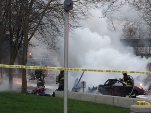 In this photo provided by KOMO-TV, emergency personnel respond to the scene of a helicopter crash outside the KOMO-TV studios near the space needle in Seattle on Tuesday, March 18, 2014 (Photo courtesy Associated Press).