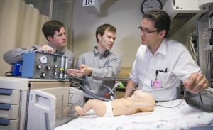 From left, Daniel Jankowski and Jordan Peterson demonstrate the NeoLife neonatal ventilator to Dr. Erick Gerday. Photo by Jaren Wilkey