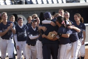 BYU softball players embrace their coach, Gordon Eakin, after winning the WCC. Photo by Natalie Stoker