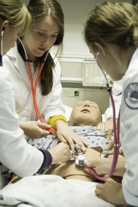 Students in BYU's nursing program practice using stethoscopes on a dummy. (Photo by Ari Davis.)