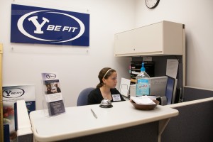 Keilah Martinez answers the phone at the Y-be-Fit office in the Richards Building. Photo by Elliott Miller