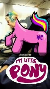 Shaun McBride turns a sleeping woman on an Airplane into a My Little Pony doll using Snapchat. McBride uses his index finger and the Snapchat app to transform ordinary pictures into wild Snapchat art. 