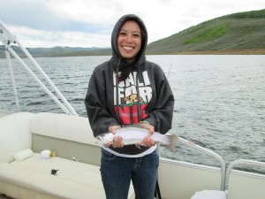 Ashley Urquhart holds a rainbow trout she caught at Strawberry Reservoir in May. (Photo by Tom Urquhart.)