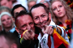 German fans react as they watch a live broadcast of the final match between Germany and Argentina at the soccer World Cup 2014 in Rio de Janeiro, Brazil, at a public viewing area called 'Fan Mile' in Berlin, Sunday, July 13, 2014. (AP Photo/Markus Schreiber)