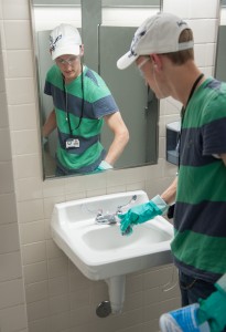 Spencer Lowe cleans a bathroom in the Jesse Knight Building Wednesday morning. (Chris Bunker)
