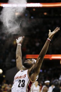 Cleveland Cavaliers' LeBron James throws talc into the air in a pre-game ritual before an NBA basketball game against the Chicago Bulls in Cleveland. James told Sports Illustrated on Friday, July 11, 2014, he is leaving the Miami Heat to go back to the Cleveland Cavaliers. (AP Photo/Mark Duncan)