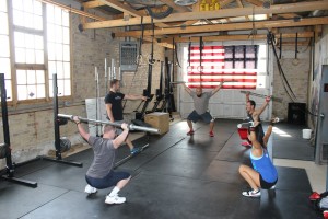 CrossFit coach Tanner Manwaring leads his CrossFit class in a warm-up routine before starting the workout in Springville. 