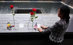 A woman grieves at her husband's memorial at South Tower Memorial Pool during memorial observances on the 13th anniversary of the Sept. 11 terror attacks on the World Trade Center in New York, Thursday, Sept. 11, 2014.  Family and friends of those who died read the names of the nearly 3,000 people killed in New York, at the Pentagon and near Shanksville, Pennsylvania.  (AP Photo/The New York Times, Chang W. Lee, Pool)