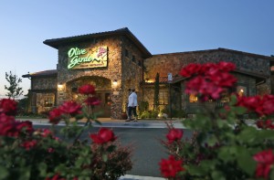 Patrons enter an Olive Garden Restaurant. Olive Garden is hurting itself by piling on too many breadsticks, according to an investor that's disputing how the restaurant chain is run. (Associated Press)